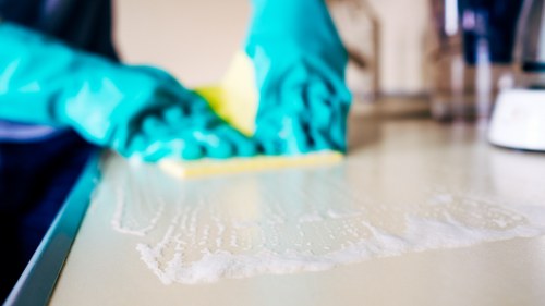 Cleaner working on upper-floor windows in Chelsea residential buildings